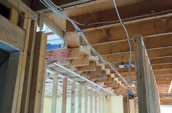 The crew built temporary support walls on both sides of the existing beam and then cut it free of the joists.