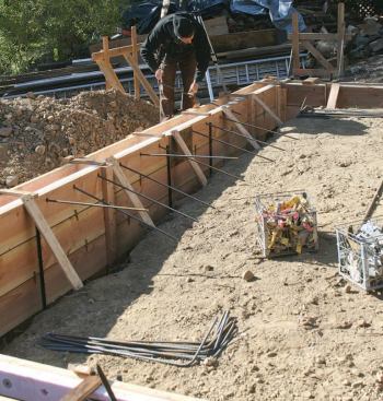 L-shaped rebar elbows inserted through the form horizontally will allow the eventual grid of rebar in the slab to be tied to the rebar in the perimeter stem wall.
