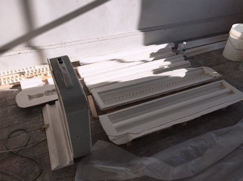To form the crown molding, our sub either pours plaster into molds (as he does for more complicated profiles like these with egg-and-dart trim)…