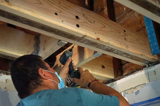 To complete the job of reinforcing  the floor system, the joists hacked up by plumbers had to be headed off.
