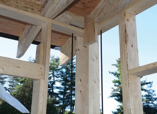 Hold-down rods — required with intermittent bracing — are installed at building corners and at regular intervals around the perimeter. They’re anchored in the foundation and continue up the walls through the topmost wall plate.