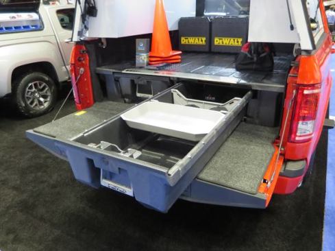 The DECKED Truck Bed Storage System fits in the bed of a pickup. Made from high density polyethylene (HDPE) the unit can support 2,000 pounds on the deck. Available for 5’6” and 6’6” beds, it has two 4’ drawers—each rated to carry 200 pounds. The drawers ride on rollers and are secured by heavy spring-loaded latches. If the tailgate doesn’t lock there’s the option to equip the drawers with keyed cylinders. The unit is 12” tall and is held in place using existing hold-downs; there’s no need to drill any holes in the bed. The DECKED storage system is available for multiple makes and models of vehicles. 
Click here for video.