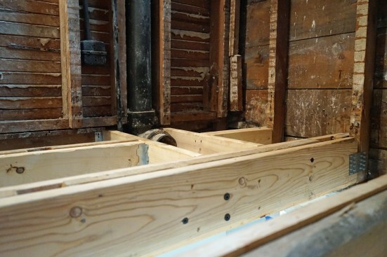 The completed framing transfers the floor load around an existing drain pipe.