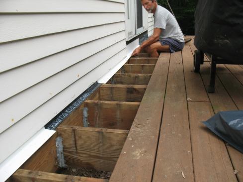 It was also necessary to remove the riser boards under the doors in order to slide the aluminum flashing into place.