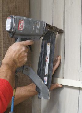 The author's crew uses both 7/16-inch crown staplers fasten shingles.