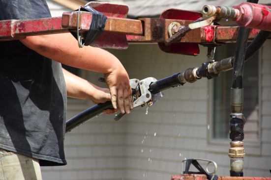 A crew member clips the end of the plastic tubing.