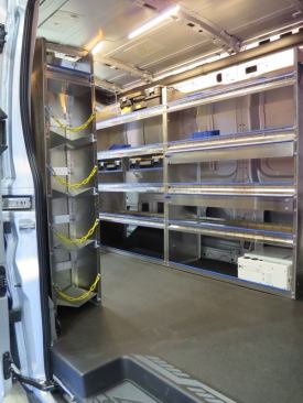 A Ford Transit upfitted with a MasteRack shelving system geared towards HVAC work. The bins on the left, with chains across the front of them are for Freon tanks. The white “box” on the bottom right is a Fleet Gold inverter.