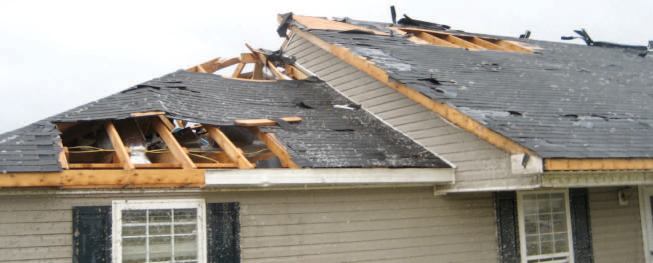 Another view of the same home shows missing sheathing on one section of the roof, probably related to loss of the lightweight vinyl soffit directly below.