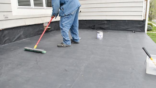 After the entire sheet is adhered, brooming continues until all the bubbles are worked out at the upper edge.