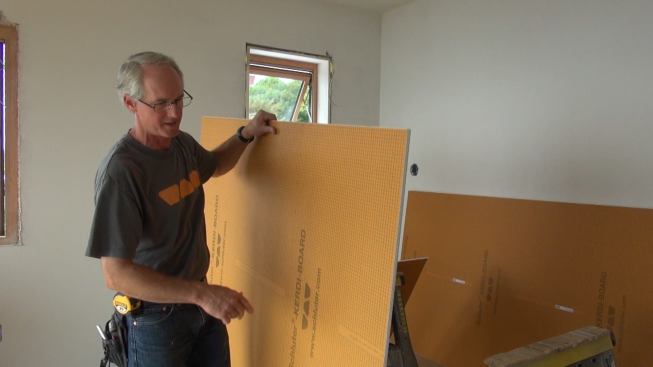 Boucher picks up a piece of Kerdi-Board after cutting it to size. The lightweight board reduces effort and fatigue for installers.