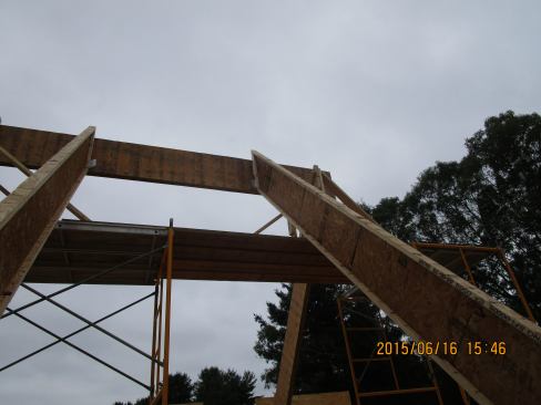 A view of the connection between the wood I-joist common rafters and the carrying ridge beam, early in the construction of the roof frame.