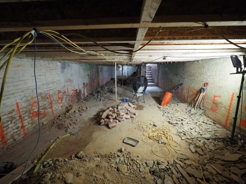 With the basement cleared, work begins on demolishing the slab, while the order of excavation of small sections is defined with spray paint on the walls. 