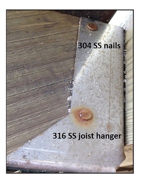 The 304 stainless steel nails are corroding after one year of being near the coast and exposed to chlorides. The 316 stainless steel joist hanger shows no signs of corrosion.