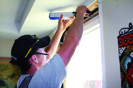 After completing the right side, the carpenter returns to the upper right-hand corner and begins working across the head of the window.