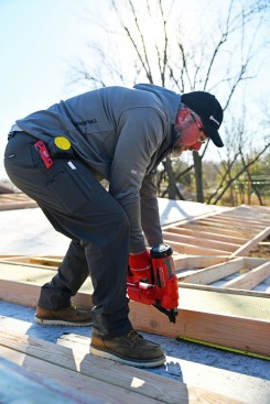 Between the overhanging sections, Joe Cook, the author’s business partner, toenails on 2x6s running perpendicular to the truss frame.