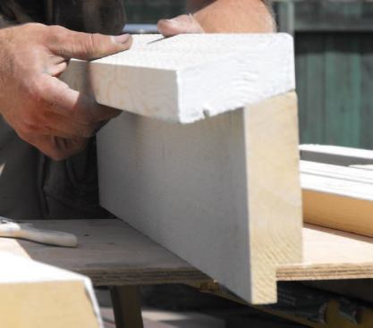 The sill is a 2x4, beveled on both edges at 15 degrees, sitting on top of a 2x6 apron with a matching bevel and a 3/4-inch-by-3/4-inch rabbet on the bottom to receive the siding.