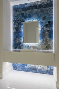 A powder room is transformed with three hand-selected slabs of blue onyx back lit to provide a floating-like effect for added drama. 