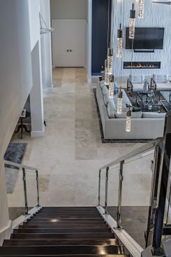 With an entirely redesigned great room, the team had to build this custom staircase that leads down into the sophisticated and contemporary yet masculine space. To achieve an open and contemporary yet masculine design, 41 West reconfigured the doors and windows, and removed walls, partitions, and even a pool bath to make room for the custom centerpiece.