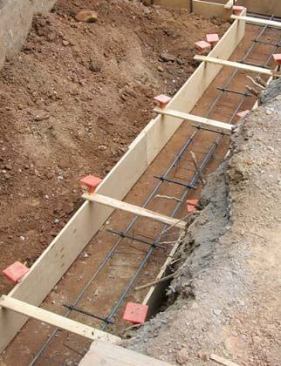 Short lengths of strapping screwed to the top of the plywood forms and backfill help strengthen the forms.