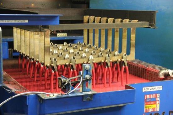 After being hung from a rack and heated in a nearby furnace, diagonal pliers are dipped into liquid vinyl to form plastic handles 
(
click here for video
).