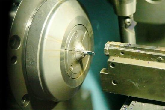 The cut steel shaft is fed in from behind this lathe chuck and Phillips tip is machined onto the end of it. The shaft is sent from here to another machine for further processing.
