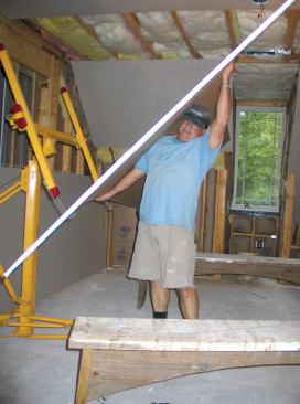 Instead of trying to hoist sheets straight up and into the Telpro panel lift, the author tilts them until their bottom edge clears the lift’s support hooks.