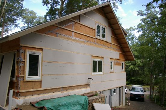 2x3s and1/2-inch plywood strips were lagged to the studs through the taped plywood sheathing. Two-inch-thick polyisocyanurate-foam sheets were installed between the 2x3 plywood nailers.