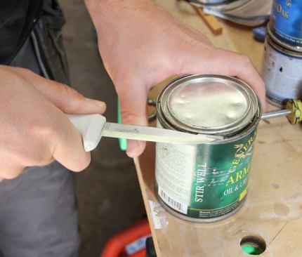 To open a can with the painter’s knife, put the bump on the back of the blade under the edge of the lid and twist the grip. It contacts more of the rim than a screwdriver would and is less likely to damage a lid that does not want to come off.