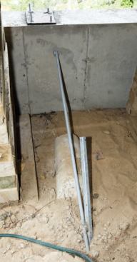 Galvanized connecting rods are attached to the angled tie-back piers.
