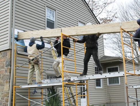 The 5 1/4-inch-by-11 1/4-inch Parallam, slid into place through a rectangular hole in the gable wall, spans the width of the garage.