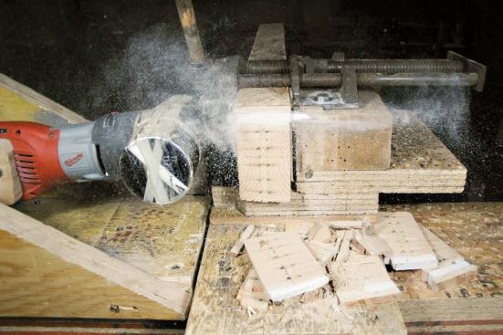 For timed cuts, a plank was clamped into a test rig and cut with a saw attached to a pivot arm. The nose of the tool was weighted to provide downward pressure - approximately 23 pounds at the blade.