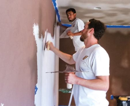 We applied the uncolored base coat to the ceiling and the colored base coat to the walls — both to about the thickness of a credit card — using 240-millimeter flexible stainless-steel rectangular trowels.