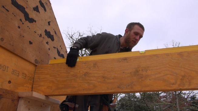Hill checks the floor beam for level.