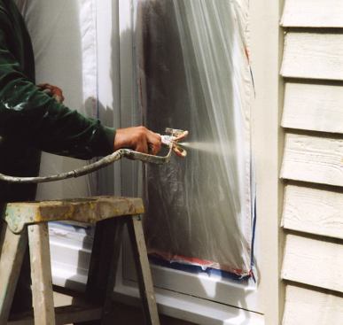 After spraying on the window's finish coat — and allowing enough drying time, so that the tape won't lift the paint — the author masks around the frame with regular tape.