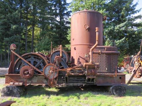 A donkey engine is a “portable” winch (usually steam-powered) loggers used to drag and lift logs. There would have been heavy wooden skids bolted to the I-beams on the bottom of this one, and after being hauled into the forest the engine could use its own cable and winch to drag itself to different locations. First used in shipping and mining, donkey engines were adapted to logging in the early 1880s. If you’re a fan of the History Channel show, Ax Men, then you’ve seen the Rygaard Crew use a yarder to drag or carry logs uphill along an elevated cable. A yarder is the modern equivalent of a donkey engine.