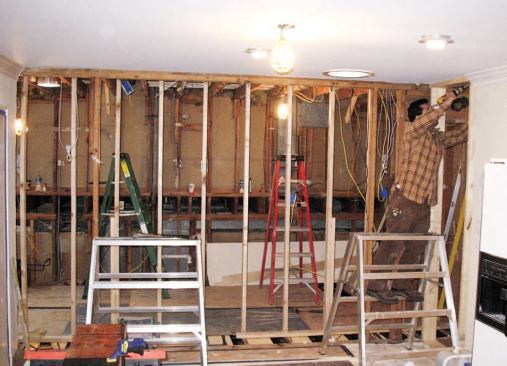 The first step in combining the two spaces was to provide temporary support for the ceiling and remove the wall in preparation for installation of a flush beam.