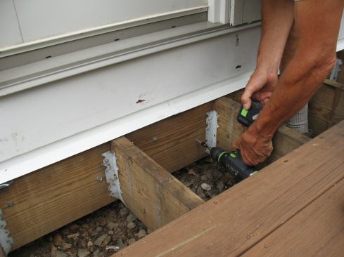 The ledger connection was reinforced with pairs of 5-inch-long LedgerLOK screws in each joist bay. The lower screws were carefully pre-drilled so that they would penetrate the center of the mudsill.