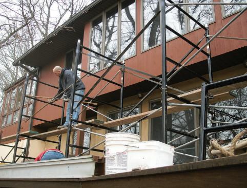 Heavy-duty pipe staging equipped with steel cradles supported a grid of aluminum I-beams used to lift the rafters off the wall.