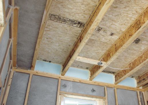 The second-floor band joists required blocks of 1-inch polystyrene, spray-foamed in place, to meet insulation goals.