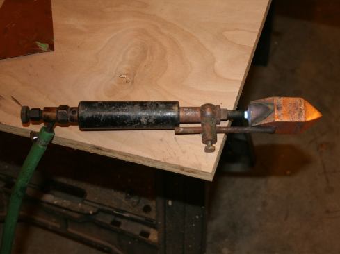 We use a pyramid-tipped, acetylene-fueled soldering iron for our roof and gutter work; propane models and other types of tips are available. Regardless of the iron or tip used, soldering requires some prep work. This photo is prior to cleaning.