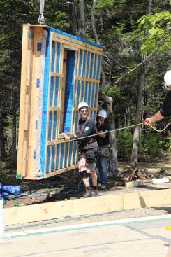 EcoCor owner, Chris Corson, guides a wall panel onto the slab.