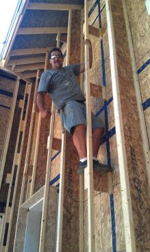 His crew is calling it the "Corson truss" — a hybrid member built up out of ripped 2x stock and short pieces of wood I-joist, used to fatten walls for super-insulation. Here, carpenter Luke Small stands on a truss web to test the system's strength. It's plenty rugged, says Corson — but on balance, he's not sure it's practical for the entire wall.