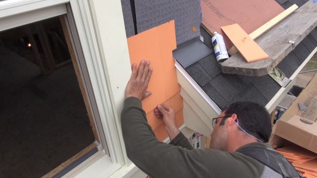 Pollard aligns the shingle butt to his level layout line.