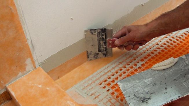 Boucher works the membrane into the mortar using a five-inch knife. He has filed the corners off the knife so that it won't gouge or tear the membrane.
