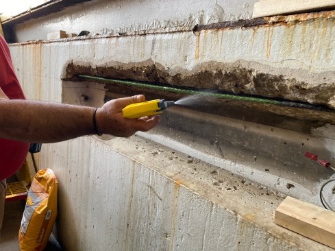 The next day after the rebar had been painted, a crew member wet down all the surface to achieve what is described in the engineer’s spec as “SSD,” or saturated surface dry.  