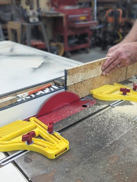 Then he flips the board over and runs it through the saw again.
