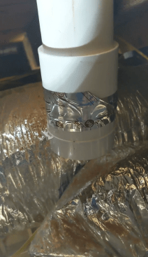 The author glues the damper assembly to the short PVC pipe on the rafter, making sure that the damper is in the appropriate closed position.