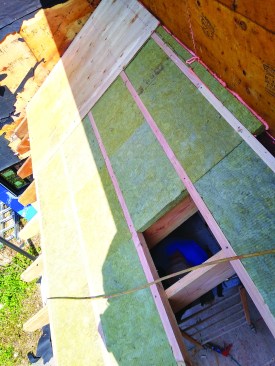 On the cathedral areas of the roof-ceiling assembly, the author added 2-inch strapping set perpendicular to the rafters and filled the voids with Rockwool 2-inch (R-8) Comfortboard 80.