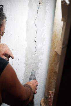 After drilling, Toby cleans out dust and loose debris from the holes and the crack.