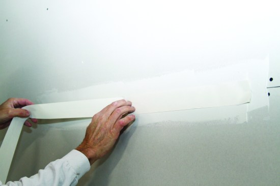 He coats the entire length (up to about 20 feet) before rolling out the tape and gently pressing it into the mud every 18 inches or so to keep it in place.